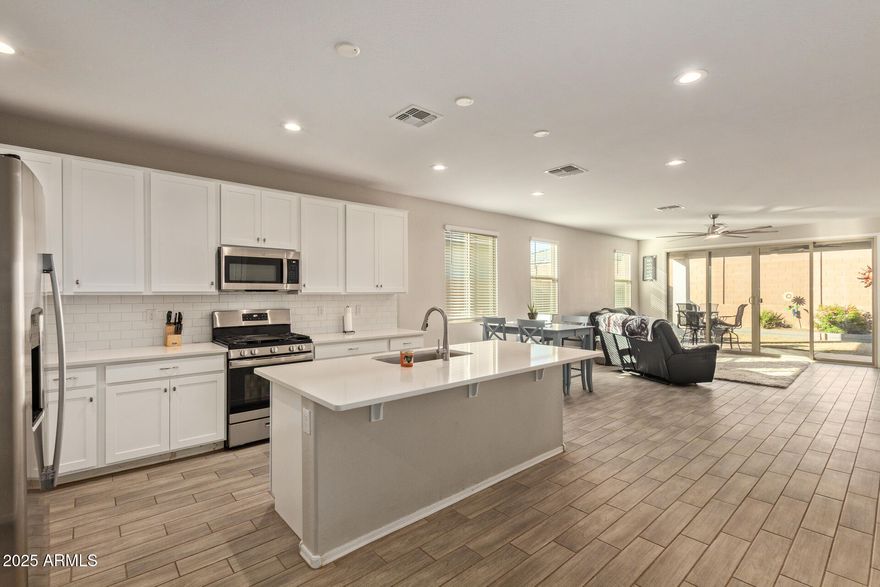 Private next-gen suite makes this home truly stand out. Complete with its own bedroom, full bath, and living area with plumbing for a future wet bar, it is ideal for multigenerational living or long-term guests while still connected to the main home. Inside, enjoy an open great room with soaring ceilings and tile wood-look flooring. The bright kitchen features white shaker cabinets, quartz countertops, stainless steel appliances, an oversized island, and walk in pantry. Spacious primary suite with dual sinks and walk in closet. 3 car garage offers room for vehicles, storage, or hobbies. Covered patio and generous backyard ready for gatherings.