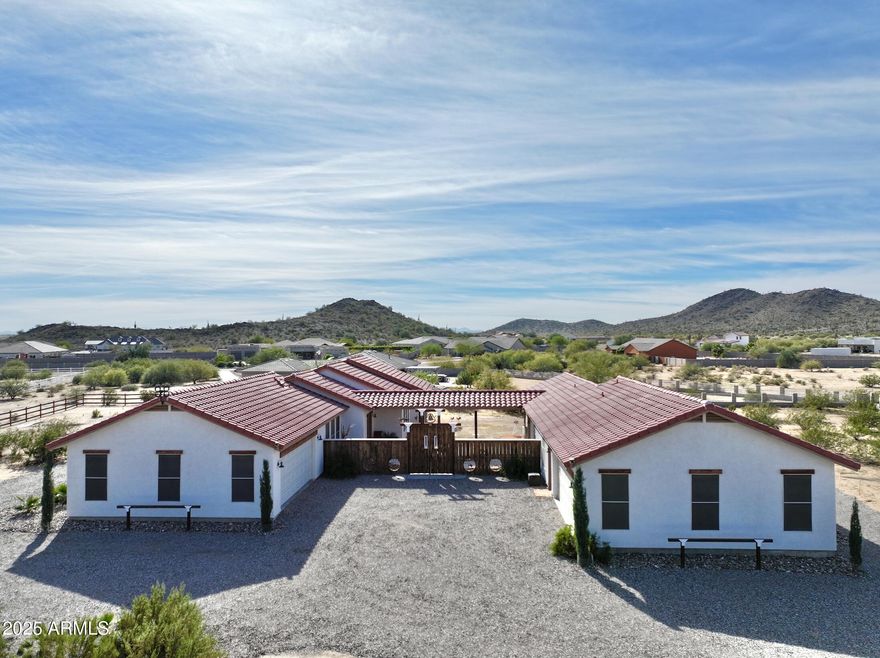 No HOA!! Set on approximately 1.14 acres with sweeping desert and mountain views, this custom courtyard-style residence offers a rare blend of privacy, flexibility, and true Southwest character.

The property features two detached living structures connected by a covered breezeway and gated central courtyard, creating ideal separation of space while maintaining a cohesive indoor-outdoor living experience.

The main residence offers a bright, open great room, tile flooring throughout, and abundant natural light. A fireplace anchors the living area, creating a warm and inviting focal point. The kitchen and dining spaces flow seamlessly and are designed for both everyday living and entertaining, featuring custom wood countertops, ample cabinetry, a walk-in pantry, and generous prep space.

The primary suite is privately positioned with direct outdoor access and a functional ensuite bath with dual vanities and custom finishes. 

The bedrooms are thoughtfully arranged and feature separate entrances and walk-in closets, offering excellent flexibility for guests, extended family, home offices, or multi-generational living arrangements.

The second detached structure provides additional living quarters, enhancing the property's versatility and privacy. This layout is ideal for guests, hobbies, or independent living space, while still feeling connected through the central courtyard and outdoor living areas.

The 2-car garage attached to the guest house also functions as a shop, it's air conditioned, insulated, and has a toilet/sink.

Outdoor living is a standout feature of this property. The gated courtyard serves as a tranquil centerpiece, complemented by multiple covered patios, open decking, and ceiling fans, making it perfect for relaxing or entertaining year-round. 

Additional features include a 4-car garage, RV hookup and parking, gated entry, gravel drive, north/south exposure, and low-maintenance desert landscaping.

The expansive lot offers ample room for customization, gardening, recreation, or future enhancements, while maintaining a peaceful desert setting. The current owners were previously planning on installing an outdoor shower and swimming pool.

The property is surrounded by scenic open space and is conveniently located near hiking  trails, with easy access to Casa Grande amenities and the I-10 freeway.

This is a rare opportunity to own a custom acreage property with a unique compound-style layout, exceptional privacy, and expansive views, perfect for buyers seeking space, flexibility, and a true Arizona lifestyle.