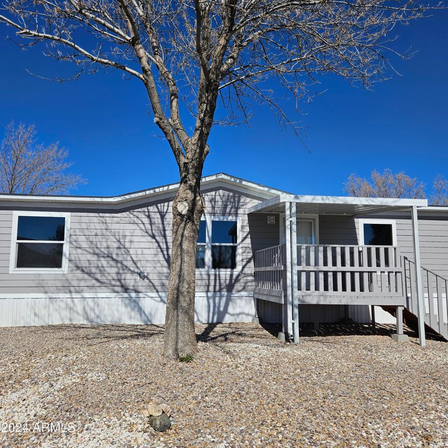 Newer home! Built in 2023. 3 bedroom, 2 bath. Open living area, 3 walk in closets, utility room is large enough for washer/dryer and upright freezer. Comfortable covered front deck! Covered carport parking for one car and concrete slabs for two more. All on a large corner lot. This gated community offers an indoor pool, an outdoor pool, a spa, and two clubhouses just to name a few of the amenities!