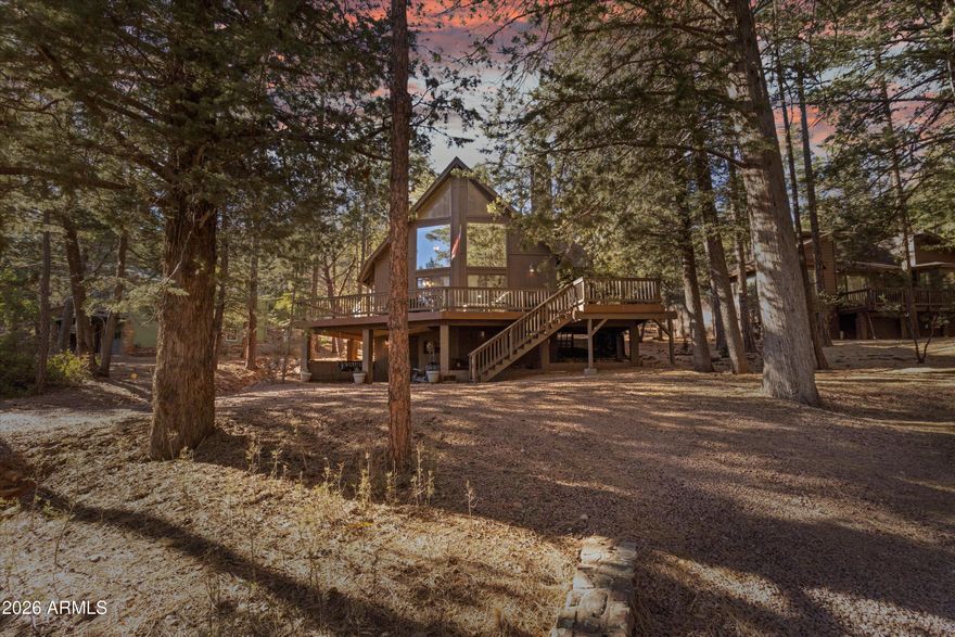 This stunning mountain cabin offers sweeping views of the surrounding mountains, framed by large chalet windows that flood the home with natural light. With sliders on both sides, the cabin opens to a spacious, wrap-around Trex deck, perfect for outdoor relaxation and entertaining. The main level features newly installed luxury vinyl flooring, while the bedrooms and downstairs area boast plush new carpeting for added comfort. The recently updated kitchen is a chef's dream, featuring beautiful granite countertops, stainless steel appliances, and stylish new lighting and fans throughout. The large open floor plan creates a seamless flow between the living and dining areas, anchored by a cozy wood-burning fireplace ideal for cozy evenings. A versatile loft space, located just outside the master suite, can serve as an office or an additional sleeping area, offering flexibility for your needs. The master suite is a peaceful retreat with its own private balcony, perfect for morning coffee or stargazing at night. The walk-out basement expands your living space with a pellet stove for warmth and an area for laundry, making it a great spot for extra relaxation or hobbies. Surrounded by tall trees, this cabin offers the ultimate mountain retreat experience, providing both seclusion and tranquility. Whether you're enjoying the natural beauty from the deck or cozying up by the fireplace, this cabin is the perfect place to escape and unwind. Don't miss out on this incredible opportunity to own a piece of mountain paradise