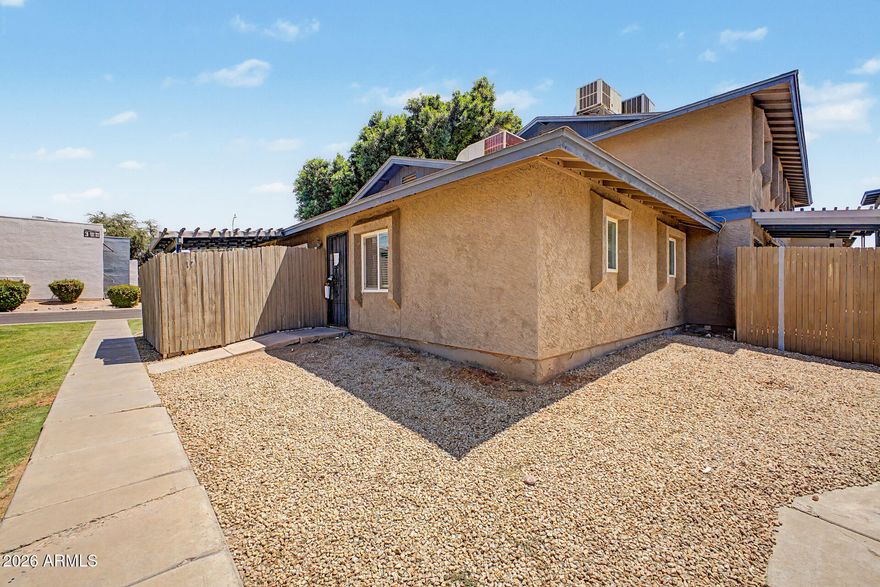 2-bedroom, 1-bath park-facing condo featuring tile and laminate flooring, ceiling fans throughout, built-ins in bedroom 2, and open living/kitchen area with recessed lighting and views of the community park. Sliding doors open to enclosed partially covered patio. Inside laundry, assigned covered parking space A17. Community includes palm trees throughout the community, pool, spa, and gazebo.