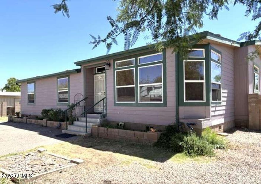 This unique and stylish gem is tucked away on .44 acres in the middle of town, close to stores, shopping, dining, schools, and more. Surrounded by a gated masonry wall, this treed lot offers a blend of privacy, tranquility, space, and convenience. The 2006 modular home sits atop attractive and durable cement and has an extra room which can be an office or study. It also includes a very attractive wood-burning rock fireplace and mantle. The large, open concept kitchen includes a center island, breakfast bar, pantry, abundant cabinetry, and storage. It opens onto the living room on one side and an ample dining area on the other. A 26'x10' screened-in porch at the back of the home is shaded by 2 large trees. In addition, the backyard has 2 sheds consisting of 1 large workshop with storage plus another large metal storage building. The treed front yard also has a double carport and is separated from the backyard by a masonry wall with 2 gates. One gate is large enough for an RV or trailer to fit through. The large yard areas provide space for many things of your choosing including RV's, trailers, pools, gardens, playground equipment, or just extra parking. This home has recently been renovated and has a new roof, fully serviced water heater and new parts, recent paint inside and out, some new windows, a new refrigerator, and more. The washer and dryer convey. It also has 2 new large pet doors to the front yard and back porch. Come view this home to experience the quiet, tranquil vibe of a country home that has the convenience of living in the middle of town!