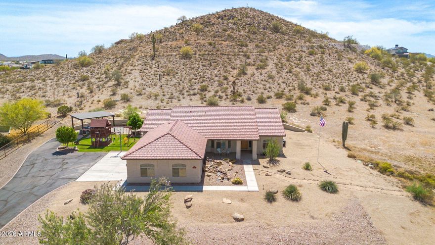 {3.43 ACRES | NO HOA | 4 CAR EXTENDED GARAGE | FULLY FENCED w/ PRIVATE GATED ENTRY}  Come see this beautifully maintained property in San Tan Valley offering space, privacy, horse privileges, and stunning mountain and desert views. The home backs to the mountain, providing added seclusion and a peaceful setting.  The expansive outdoor setup features a designer water feature at the front entry, an extended covered patio with above-ground spa, pergola seating area, grassy play space & playground, storage shed, and a 3-bay RV shade with poured concrete slab and drive-through access--perfect for all your toys. Inside, the open 4 bedroom, 2 bath split floorplan offers fresh interior paint, vaulted ceilings, plush carpet, and a gorgeous gas fireplace in the family room.  See MORE Remarks... The kitchen includes granite countertops, SS appliances, and upgraded cabinetry. The primary suite features double-door entry, 5-piece en-suite bath w/ soaking tub, and a walk-in closet. One secondary bedroom w/ double doors is ideal for a home office or flex space. The extended 4-car garage includes built-in cabinetry, offering generous storage and workspace, with approximate dimensions of 24x40 ft (960 sq ft) and oversized 16x8 ft garage doors. In addition, the 12x28 ft outdoor storage shed has two upper storage areas, providing approximately 612 sq ft of versatile extra storage.
This is a rare opportunity to own acreage with privacy, views, and room to live, play, and grow--all in one.