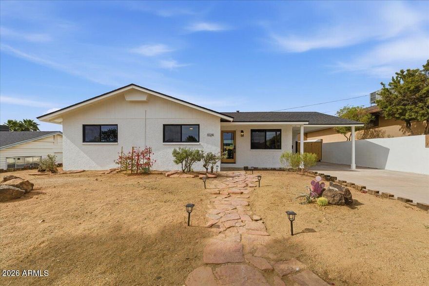 Stunning top-to-bottom renovation in the foothills of North Mountain - one of North Central Phoenix's most desirable neighborhoods. This fully transformed 4-bedroom, 2-bath home left nothing untouched. Brand-new kitchen with a large island, modern cabinetry, stainless appliances, and brass pendant lighting flows into a dining area and two separate living spaces - true flexibility for how you use the home. Every major system is new: roof, HVAC, windows, flooring, and fresh paint inside and out. Outside, the backyard is built for Arizona living. A covered patio with a built-in outdoor kitchen, grill, and beverage fridge is ready for year-round entertaining. A separate gated courtyard with a stone fireplace creates a private second outdoor retreat.