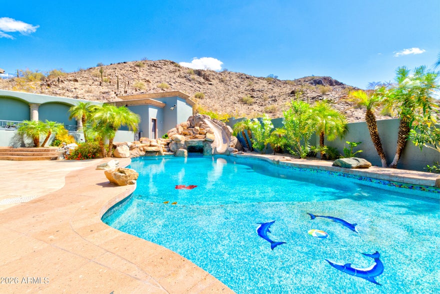 Located in the prestigious gated community of Canyon Reserve, this custom luxury home features ICF construction (solid concrete, wrapped in insulation) for exceptional efficiency and durability. Designed for indoor-outdoor living, enjoy a resort-style backyard with pool, waterfall, grotto, and slide, plus expansive covered patios and a full outdoor kitchen. The home offers multiple ensuite bedrooms, a private casita with kitchenette, game room with balcony, theater with snack bar, and a versatile lower-level flex space. A rooftop deck captures mountain views, and an in-home elevator adds everyday convenience. Exceptional design, quality, and lifestyle throughout. This custom luxury residence blends thoughtful design, quality construction, and exceptional indoor-outdoor living.

A grand entry opens to formal living and dining spaces, leading into a spacious great room and a well-appointed kitchen designed for both everyday living and entertaining. Rich finishes, custom cabinetry, and quality materials are carried throughout the home.

The flexible floor plan includes multiple ensuite bedrooms, offering comfort and privacy for family and guests alike. A standout space functions as a bedroom, library, or home office, complete with custom built-ins and its own private bath. The primary suite provides a true retreat, while additional bedrooms include both private ensuites and a thoughtfully designed Jack & Jill layout.

The game room serves as a central gathering space, featuring a built-in bar and direct access to a private balcony with mountain views--perfect for relaxing or entertaining. A dedicated home theater with tiered seating and a snack bar creates a true cinema experience.

Outdoor living is where this home truly shines. The resort-style backyard features a pool with waterfall, grotto, and slide, surrounded by expansive patios designed for entertaining. A full outdoor kitchen, covered dining areas, and multiple seating spaces create a seamless indoor-outdoor lifestyle ideal for Arizona living.

A detached casita offers a private retreat for guests, complete with its own entrance, kitchenette, and full bathroom--ideal for extended stays or multi-generational living.

Additional features include a rooftop deck capturing sweeping mountain views, a lower-level flex space ideal for a gym, studio, home business, or hobby area, and an in-home elevator connecting the garage level to the main living area for added everyday convenience.

From its versatile layout to its resort-style amenities, this home offers a rare combination of luxury, functionality, and lifestyle.
