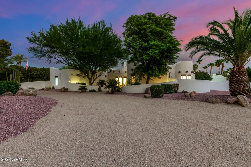 Just WOW! Welcome to a residence where sophistication meets desert elegance. Greeted by a graceful circular drive, this home boasts a striking facade complemented by a 3-car garage, convenient RV gate, and a meticulously curated desert landscape. Enter the living room that envelops you with its grandeur. Soaring ceilings featuring exposed beams that elevate the space creating an open yet intimate atmosphere. Entertain guests with a drink at the strategically placed wet bar while abundant natural light cascades in, accentuating the contemporary wood-look flooring. The formal dining room provides an elegant space for memorable meals and gatherings. Fabulous yard featuring bocce court, bar b que, firepit,lush landscaping,  citrus, sparkling pool & spa and casita for total privacy..... The kitchen is a culinary masterpiece, equipped with a cozy breakfast nook, quartz countertops, and a matching backsplash, gleaming under the skylights and recessed lighting. SS appliances, timeless shaker cabinets adorned with crown moulding, and a central island make meal prep a delight. The added pantry ensures ample storage, and a peninsula with a breakfast bar provides a hub for casual dining. The main bedroom offers direct backyard access and brings nature close, while the ambient glow from the two-way fireplace adds a touch of romance. The en-suite bathroom, a spa-like retreat, features dual vanities and a spacious walk-in closet to satisfy all your storage needs. Venture outdoors to the vast backyard, a true entertainer's paradise. A covered patio beckons for alfresco dining, leading to a comprehensive outdoor kitchen. Gather around the fire pit on chilly nights, or dive into the sparkling pool during warmer days. The pristine lawn is an oasis of green, while a separate guest house ensures privacy for visitors. After a long day, immerse yourself in the calming spa, letting its therapeutic waters soothe you. A gem like this is a rare find! Make it yours before it's gone!
