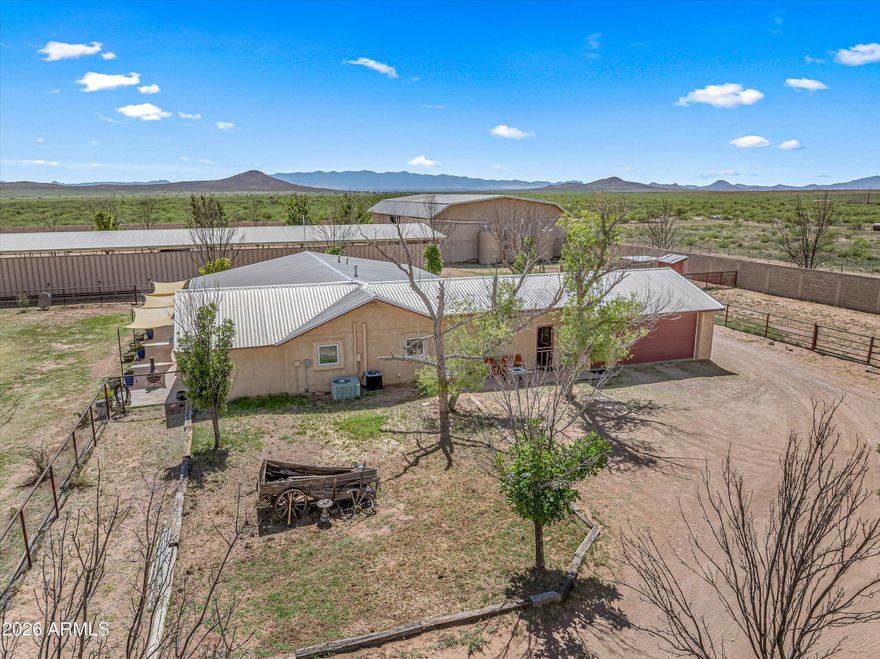 Welcome to Antelope Rd - The Yaqui Hideout, an exceptional 30-acre working ranch retreat where wide-open skies, breathtaking mountain vistas, and unforgettable Arizona sunsets create the ultimate backdrop for authentic country living. Nestled in the heart of Arizona's high desert and just off the renowned Willcox Wine Trail, this extraordinary property offers not only privacy and ranch functionality but also access to some of Southern Arizona's most celebrated outdoor recreation, world-class bird watching, and endless adventure. Set on 30 private acres, 4 tucked behind a 10-foot block wall and secure gated entrance, this remarkable estate offers the rare opportunity to embrace the ranch lifestyle with privacy, infrastructure, and space to truly make it your own. Imagine ending each day on the porch, watching the sun dip behind the mountains as the sky transforms into brilliant shades of gold, crimson, and violet, while your livestock settle in for the evening and the peaceful rhythm of ranch life takes over. Designed for both comfortable living and agricultural functionality, the home is perfectly suited for raising livestock, equestrian pursuits, homesteading, or operating a destination ranch retreat. Currently operating as a successful bed & breakfast, it offers incredible flexibility as an income-producing property, private family compound, or legacy ranch estate. The main residence features 4 bedrooms, 3 bathrooms, and a kitchenette, while the separate bunk house offers 5 additional bedrooms and 4 bathrooms (5th option), creating abundant accommodations for guests, ranch hands, retreats, or multi-generational living. A versatile fifth bedroom currently serves as a basket weaving studio, offering flexible space for creative pursuits, office use, or additional guest quarters. Built with the rancher in mind, the property is exceptionally well-equipped with a 6,120 sq. ft. barn, three 5,000-gallon water harvesting tanks, a private 500-foot well, pump house, owned propane tank, RV garage, equipment shed, greenhouse, and chicken coop. Livestock operations are fully supported with 8 pens inside the walled compound, an outdoor riding arena with 12 additional livestock pens, and 7 established pastures plus a fragrant lavender field, offering 8 total grazing and agricultural areas across the property. Perfectly positioned near the stunning Chiricahua National Monument, the property places you minutes from exceptional hiking trails, dramatic rock formations, scenic canyons, and some of the finest birding destinations in the country. Outdoor enthusiasts will appreciate easy access to hiking, horseback riding, wildlife viewing, stargazing, and exploring the rugged beauty of both the Dragoon and Chiricahua mountain ranges. Wine lovers will enjoy nearby tastings and vineyard experiences along the Willcox Wine Trail, making this location an ideal blend of rural tranquility and destination appeal. Whether your dream is raising livestock, riding beneath endless desert skies, cultivating the land, welcoming guests seeking adventure and serenity, or simply savoring spectacular sunsets from your own private ranch sanctuary; a rare chance to own a true piece of Arizona's rural beauty, where every sunset reminds you that you're exactly where you belong.