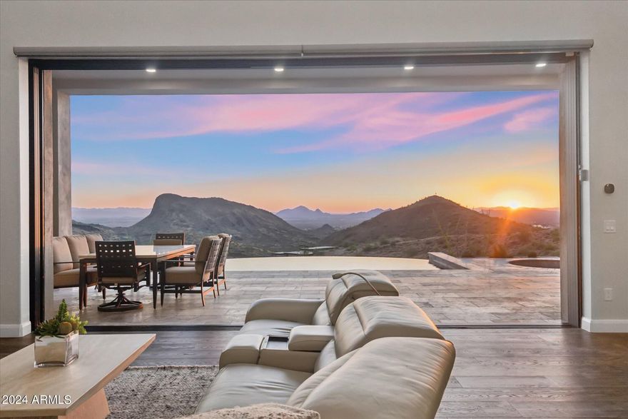This stunning 2022 build is a quintessential soft contemporary home, offering a seamless, one-level layout with no steps. Situated atop a ridgetop, it boasts unparalleled, unobstructed airliner views that stretch from Four Peaks to the Fountain, Camelback Mountain, and sweeping vistas of Phoenix, Scottsdale, Tempe, and Mesa city lights.

Designed with elegance in mind, this gorgeous 3-bedroom, 3-bathroom home features an open-concept floor plan, ideal for those who love to entertain while enjoying breathtaking scenery. The chef's kitchen is a dream, complemented by high-end finishes throughout. A striking 20-foot beamed ceiling in the great room creates a grand atmosphere, and the 20-foot retractable slider invites effortless indoor/outdoor living, perfect for enjoying the Arizona climate.

Additionally, the oversized 2-car garage and an expansive 35-foot deep RV garage offer plenty of space for vehicles, while also being ideal for a classic car collection or a golf simulator room. Outside, the travertine pool deck, hot tub, and negative-edge pool elevate the sunset experience, making this home a true private sanctuary.