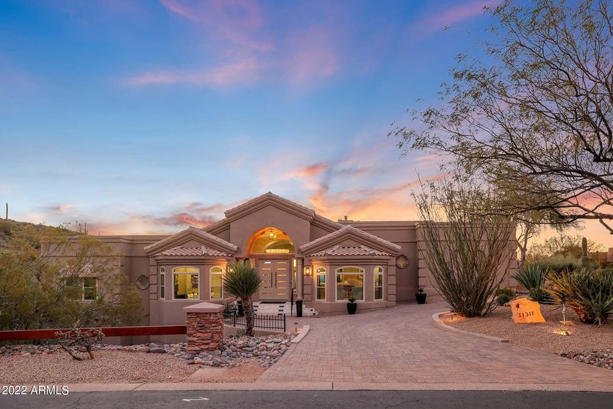 Here is your opportunity to own this stunning home in the gated community of Troon Ridge Estates! This 4 bedroom, 4.5 bath is situated on 1.44 acres with exceptional one-of-a-kind 360-degree views of the valley and its sunsets. Nothing has been spared in the renovation of this 4500 square foot home, inside or out. This home offers all the amenities and convenience that you come to expect in a modern home. As soon as you enter the home you can see what separates this home from others. The spacious floor plan is the ultimate in luxury featuring Italian marble flooring, Hievonynas chandelier, tray ceilings, modern luxury fireplaces, arched openings, new windows, new doors, and HVAC systems. The Imported Poggenpohl German kitchen features custom cabinets and drawers, state of the art Samsung and Miele appliances, induction cooktop, porcelain, and quartz counters. The eat in kitchen has full retractable pocket doors to enjoy the spectacular outside views. The primary bedroom features a floor to ceiling slate fireplace, plank flooring and double doors leading to your own patio with spectacular mountain views. The ensuite features marble flooring, dual access walk-in shower, and large elegant soaking tub. With two other bedrooms and ensuites on the primary level, they offer modern luxury and privacy with their own amazing views.  The lower level of the house features the spacious fourth bedroom and it's ensuite. The outdoor resort like living area boasts multi-levels for entertaining with a built-in outdoor kitchen. You will enjoy sitting by the fireplace with a bottle of wine or relaxing in the heated pebble shine pool and spa all while enjoying some of the best views and sunsets the valley has to offer. While in the climate controlled three car extended length garage, you'll find a bonus room ready for any of your office, art, crafts or workout needs. Within Troon you will be able to enjoy some of the finest dining, world class events and amenities Scottsdale has to offer within a short distance from your door.