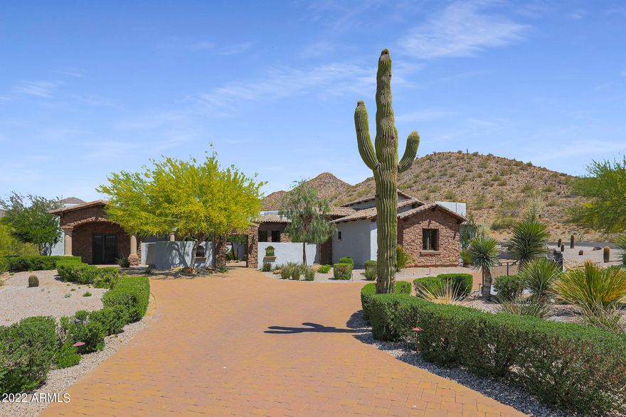 This custom home nestles at the base of the mountain which lends spectacular views and privacy! At the end of the cul-de-sac, this location is for the most discerning! Enter through the secure courtyard into the living room. Notice the beautiful fireplace. The open concept in the great room offers a luxurious kitchen with all of the desirable appliances including the double ovens. The large island is perfect for entertaining while the chef prepares the gourmet meals! Notice the 1000 bottle wine room as you mosey over to the movie theater. The floor plan is split and the master bedroom and bathroom are a show stopper! The two separate closets with islands, the large soaking tub, fabulous shower and separate vanities create a spa like experience.