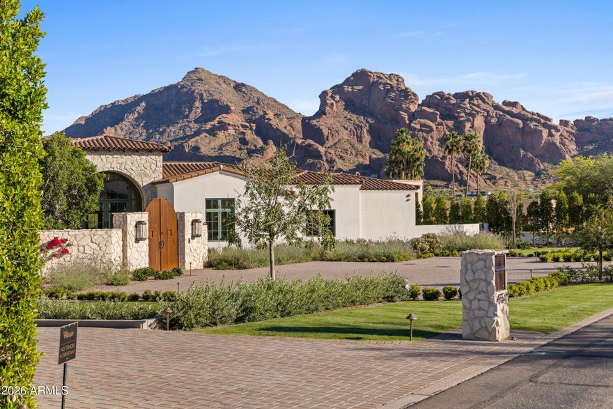 Newly built in 2025, this exceptional Paradise Valley residence blends a refined transitional style -- melding the warmth of Santa Barbara architecture with modern design plus top-tier finishes -- and captures dramatic views of Camelback Mtn, including the Praying Monk and Head of Camelback. The great room features soaring 18-foot ceilings and a dramatic Italian tile fireplace, opening to outdoor living with a fully tiled negative-edge pool, manicured lawn, and a premium Hestan grill and pizza oven. The chef's kitchen is anchored by BlueStar appliances, a spacious back kitchen w/ additional appliances + walnut Artitalia cabinetry with special organizers. A luxurious primary wing offers a unique glass sauna with contiguous glass steam shower, dual towel warming drawers, 2 large closets... plus a long glass shelved hallway to showcase handbags. Crestron automation, Palecek lighting and quartzite cristallo counters Enhance the sophisticated feel of the home. Additional highlights include a large brick ceiling wine room, a theater, office, mudroom cabinetry and dog wash station.