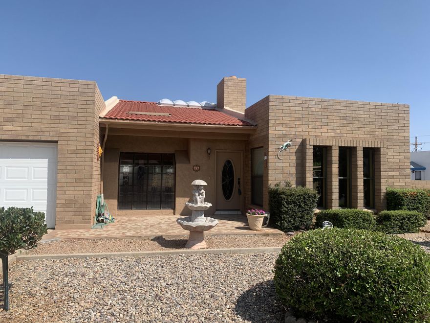 Beautiful upscale large family home with custom mosaic tile front porch. A 3 bedroom, split floorplan, separate laundry room with abundant storage cabinets, new garage door opener, 2 baths with elegant custom vanities.   Breakfast nook, living room, dining room, fireplace, den, 3 French doors leading to 500 sq foot heated Arizona Room. Lovely landscaped backyard with RV gate, shed with electricity and shady dog run with mature trees.  Newer low-e custom windows throughout, stainless steel appliances, pullout drawers, new ss range., touch-less faucet in kitchen, granite throughout. Custom neutral tile throughout and new laminate flooring in dining room. Roof recently inspected by licensed contractor and repairs completed. Show and sell this beauty!! Records show that existing square footage of 2300 ft does not include the 500 feet in Arizona Room, bringing total square feet to approx. 2800 ft.