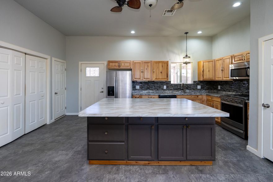 NEWER built 2019! Bright & Open great room floor plan with a desirable split-bedroom layout, offering 3 bedrooms and 2 baths. The spacious kitchen is designed for both function & entertaining, featuring abundant storage, generous counter space, and an OVERSIZED CENTER ISLAND--perfect for entertaining, family get-togethers, cooking, canning, crafts, and more. The large primary suite provides a relaxing retreat with an oversized walk-in shower and a spacious walk-in closet. Step outside to the screened-in patio, complete with an above-ground spa--ideal for enjoying Arizona's beautiful year-round weather. Additional highlights include RV gate access from the alley with ample space for RVs, recreational vehicles, trailers, & toys. Freshly painted, impeccably clean & truly ''Move-In Ready''!