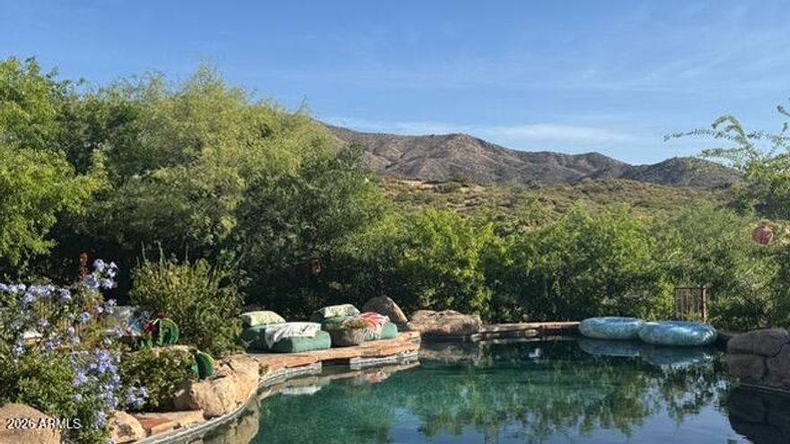 Custom pretty pueblo ideally seated on 3.5 acres for total privacy with multiple outdoor lounge/dining areas and spectacular vistas/views of Four Peaks, Weaver's Needle with Tonto National Forest surrounding. Three en-suite bedrooms, dedicated office with new wood flooring, new HVAC's, new appliances and new custom interior and exterior lighting. Botanical secret gardens curated for the enjoyment of all in residence enchant year round. The pool patios are totally private with covered dining multi lounge areas that capture the Sonoran skies at their most beautiful. Remodeled primary suite and guest suite with hand painted tile in both. This offering includes 2 parcels.