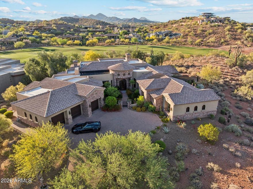 Privately gated and gracefully positioned along the 14th fairway of Fire Rock Country Club, this home enjoys a premier golf course setting. This distinguished single-level residence embodies the privacy, elegance, and quiet grandeur that define luxury living in Fountain Hills. Surrounded by mountain views and designed without interior steps, the home balances impressive scale with a floor plan that feels both intimate and exceptionally functional.

A refined interior unfolds through soaring ceilings, wood-framed windows, and beautifully selected finishes that lend warmth and permanence throughout. The living spaces are open yet intentional, designed to flow effortlessly from one room to the next and out to the resort-style backyard beyond. At the center of the home, the kitchen is both polished and practical, featuring custom cabinetry, granite countertops, a large prep island with sink, breakfast bar seating, Dacor appliances, a walk-in pantry, and a light-filled breakfast nook.

Designed for effortless everyday living, the home is enhanced by a robust smart-home system that integrates Nest climate control, Lutron lighting, automated blinds, Sonos audio, MyQ garage access, Alexa and iPhone connectivity, and iAqualink control for the pool, spa, lighting, and water features. Four zoned HVAC systems, three gas water heaters with recirculation, central vacuum, and a climate-controlled garage further elevate comfort and efficiency throughout.

The primary suite offers a luxurious sense of retreat, complete with wood flooring, a spacious bath with jetted tub and separate shower, dual vanities, a dedicated makeup station, and dual walk-in closets. Secondary en-suite bedrooms, a private office, and a reimagined attached guest wing add versatility without compromise. Originally conceived with a detached casita, the home has since been thoughtfully reconfigured by enclosing the breezeway, creating guest quarters that feel fully integrated into the main structure.

A rare added amenity, the home also features a professionally designed indoor golf simulator, creating an exceptional at-home experience for practice, entertainment, and year-round enjoyment.

Outside, a dramatic three-sided negative-edge pool and spa, artificial turf, expansive covered patio, built-in BBQ, gas fire pit, and cooling misters create a backyard designed for both relaxation and entertaining at the highest level. With its premier fairway setting, sophisticated appointments, and timeless appeal, this is a home of uncommon quality and distinction.