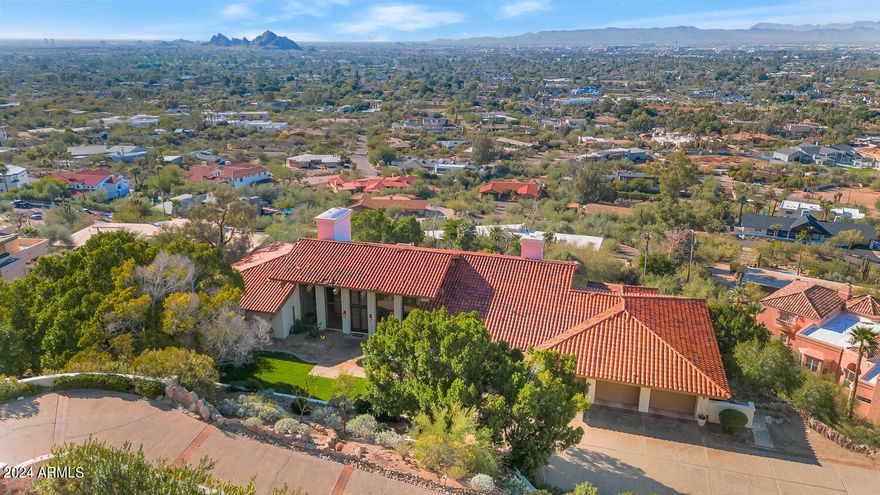 If you've dreamt of living high atop the city nestled into Camelback Mountain in a setting so breathtaking it's unimaginable, your search may have just ended. This special home is filled with natural sunlight and beautiful living spaces. Each room has its own unique design traits that take full advantage of the spectacular views. The kitchen is lovely, the great room has a grand fireplace as its focal point, the formal dining room has its own fireplace that creates exceptional ambience, the office is spacious and private, and the primary suite is a dream worthy place to begin and end each day. The special design features tongue and groove ceilings, exposed wood beams, intricate millwork, a restaurant style walk-up wet bar, and floor to ceiling picture windows.  The magnificent lot is over an acre and has a full guest house, putting green and exquisite negative edge pool overlooking the entire city with pristine unobstructed views as far as the eyes can see. This impeccable residence offers a setting so exquisite, so unique and so rare in one of the most desired areas in all of Phoenix. City lights, mountain views, hiking out the front door in a world class neighborhood, what more can you ask for?