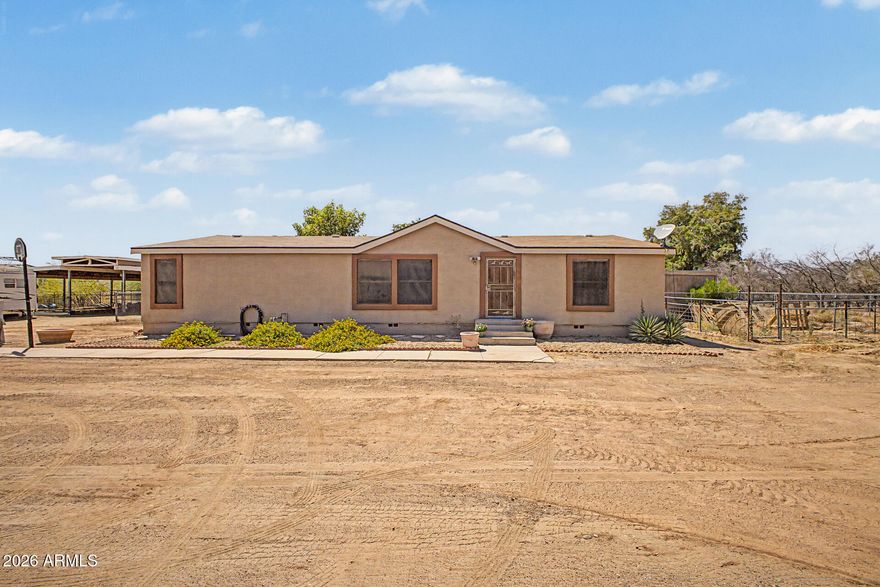 Welcome to this manufactured home on desirable horse property! With East/West exposure & a setting along unpaved roads, this property delivers privacy, open skies, & room to roam. Inside, you'll find a warm interior featuring a mix of tile & wood flooring, dual-pane windows, & a brand new A/C system. The cozy family room provides a space to relax, while the kitchen has laminate counters, a breakfast bar, & a charming breakfast nook. Split main bedroom offers a well-appointed bathroom with dual sinks & a walk-in closet. Additional features, such as baseboard heating, enhance the home's functionality! Enjoy a grassy backyard with a covered patio, an RV gate, an RV hookup, ample storage space, & updated septic system. Horse enthusiasts will appreciate the dedicated stall & arena! Must see!
