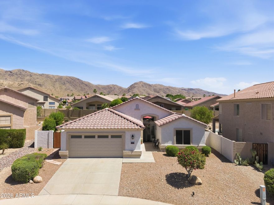 Wake up each day to breathtaking, unobstructed mountain views of the stunning Estrella Mountains from your front door. In the highly sought after Ahwatukee Foothills of Phoenix, this beautifully maintained home is tucked away on a quiet cul de sac with only 3 neighboring homes. This property delivers a rare sense of peace and seclusion. Enjoy peace of mind knowing the major updates have already been completed, including roof (2021), HVAC (2019), water heater with thermal expansion tank (2024), insulated garage door (2024), garbage disposal (2026), new toilets (2026), Ring doorbell and security system, plus freshly painted cabinets, switches & medicine cabinets in 2026. The 1,854 sq ft floor plan offers 3 bedrooms plus a large den currently used as 4th bedroom making it ideal for guests, a home office or flex space. The kitchen is built for everyday living and entertaining with abundant cabinet and counter space, stainless steel appliances and a large breakfast bar that overlooks the expansive family room. Vaulted ceilings and wall to wall windows fill the home with natural light, creating a bright and welcoming atmosphere. The private primary retreat is a true escape with direct access to the covered patio, a soaking tub, walk in shower, dual vanities and a generous walk in closet. The backyard is designed for both relaxation and fun, featuring an extra tall privacy wall, no two story homes behind you and a sparkling pool where you can sunbathe in complete privacy or cool off on warm Arizona days. There is plenty of space for backyard barbecues, entertaining, kids and pets to play, plus a removable pool fence for added child and pet safety. There is truly nothing left to do but move in and start enjoying the lifestyle this home offers. Live just minutes from endless hiking and biking at South Mountain Preserve, only 3 miles away, with shopping, dining and everyday conveniences close by. Best of all, Loop 202 is only 4 minutes away, giving you quick access to anywhere in the Valley. This is Arizona living at its finest.