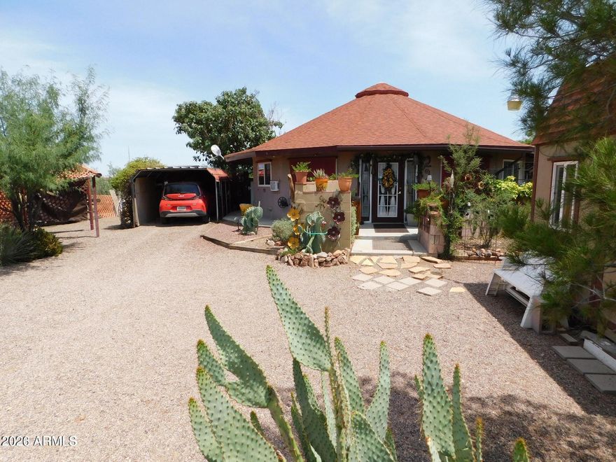 Shows like a model home worthy of magazine covers due to the current seller's attention to detail. This amazing retreat has 5 total tax codes and is on 2.28 acres. There is a shared well which is tested weekly by the water management company. A 2 bedroom - 2 bath plus Arizona room offers Zen-like features and curves. The aerodynamic properties of a circular home make the houses more resistant to harsh weather. The floor plan and design of this unique beauty invite positive spirituality and creativity. The seller has designed some of the most inviting and beautiful desert life gardens in the area. The circular Drive is one parking & entry area, but there is also an older entry off of Pueblo Dr. & one behind the home off of the extra ... ...North lots of this property giving THREE
 separate possibilities of parking-entry & exits plus bringing in feed or adding stables, barn, arena, Or possibly Guest Home or office. Check with zoning.

The AMAZING ZEN Arizona Room is approximately 240 sq. feet and can be enclosed to make it another bedroom - office or whatever a buyer might need. Currently heated and cooled with wall units when needed.

There are 2 fantastic sheds already on the property as well as a designer hen house. One shed on the South side of the home has an attic.

This is an ENERGY EFFICIENT GREEN HOME***
The bathroom sinks and showers allow gray water to benefit the gardens, and there are also barrel water catchers available for the new owner to attach to the roof to collect rainwater.
The seller currently has 2 amazing portable AC units plus two window units that stay with the home. Plus ditech shades across the front of the house block 90% of UV rays making electric bills low - $80-$135 a month depending on the season.

The Master Bathroom has a stackable washer and dryer hook up and the hook up for the toilet is there just needs a toilet as this room was being used for laundry only but the plumbing is all available and used to have a toilet. There is space on the Arizona Room Patio to make a laundry room - The Master bathroom has a Shower and sink and wash/dryer hook up.

Fabulous mature tress and desert vegetation surround the home and private patios. A Large Tombstone Rose shades the small backyard, as well as mature grape vines.

The tax codes are : 406-24-540E Home on 0.58 acres - 406-24-540 C is 0.37 Acres/ 406-24-536 is 0.37 Acres /406-24-531 is 0.59 Acres and 406-24-532 is 0.37 Acres = Total 2.28 Acres with the home.