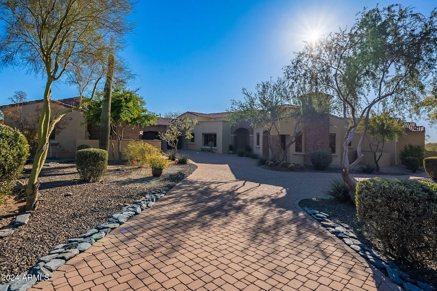 Welcome to 5681 E Canyon Ridge Dr, an exquisite 5,334-square-foot home on a sprawling 1.257-acre lot in Cave Creek, Arizona. This residence seamlessly blends elegance, comfort, and practicality in the serene Canyon Ridge Estates. Featuring four oversized ensuite bedrooms with large walk-in closets and 4.5 beautifully designed bathrooms, this home also offers a versatile office that can double as guest quarters or a media room. A spacious 4+ car garage provides ample room for vehicles, toys, and storage. Inside, the chef's kitchen shines with side-by-side 36'' Sub Zero refrigerator and freezer units, luxury granite countertops, high-end appliances, an ice maker, and wood beam ceilings that continue into the family room for warmth and charm. Stone details tie together the kitchen, family room, and formal dining areas, while a wet bar with wine storage and a convenient dog shower in the laundry room add thoughtful touches. The backyard retreat features a custom pool with water features, southwest exposure for breathtaking sunsets, and a lush turf area ideal for play or gatherings. With ample space for additional customizations, the outdoor area is perfect for creating your dream oasis. Located minutes from Cave Creek's vibrant restaurants, shopping, and outdoor recreation, this home offers privacy, stunning desert views, and the best of Arizona living.