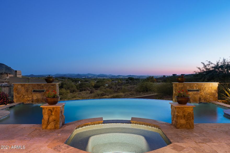 This custom home has SHOW STOPPING views of the valley! The pocket doors in the living room allow for an incredible indoor/outdoor space overlooking the pool & hot tub. Cooking in the chef's kitchen makes life easy-gas cooktop, 2 refrigerators, walk-in pantry & giant island. The impressive master suite has it all! His & hers closets, soaking tub, sitting room, fitness room (all with views), urinal & a sauna along with french doors to the patio. Each en-suite bedroom offers a walk-in closet, patio & views of Pinnacle Peak. There are 2 attached guest houses both with access to the garage & private entrances. The grounds are grand too! With a rooftop deck, 2 gas fire-pits, an outdoor BBQ & half bath for the pool, you are ready to entertain & take in the breathtaking Arizona sunsets!