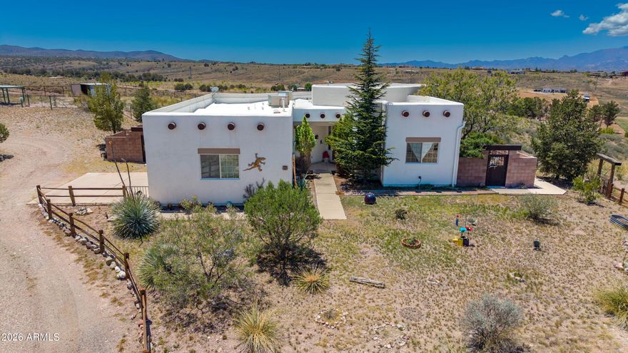 Two-story Santa Fe home in Sonoita Wine Country on 4.78 acres w/panoramic Mountain views! The 3,057 sq. ft. split-level offers 4 BR/3 BA, 2+ car garage & outbuilding(s). Main level (1,882 sq. ft.) features a Great Room, dining area w/private patio, U-shaped kitchen, large pantry, laundry to garage, high ceilings w/viga beams, & French doors to a balcony. Primary suite has spacious bath & oversized closet; 2nd BR/study has private exterior access. Lower level adds 1,175 sq. ft. family room, wet bar, 2 BR, full bath, storage & covered patio/gazebo--ideal for guests, studio, office or B&B. Paved-road access. Providing easy access to all the amenities & attractions that Sonoita's wine country has to offer. (Watch out for the deer/wildlife while driving in.) Welcome to your new home! Santa Fe Home in Sonoita Wine Country
Nestled in the heart of wine country, this two-story Santa Fe home is situated on 4.78 acres of rolling ranch grassland. Surrounded by the Huachuca, Whetstone, Mustang, Santa Rita, and Empire Mountains, ensuring breathtaking views from every angle.
Home Features
Spacious 3,057 square feet split-level floor plan, this residence offers four bedrooms, and three bathrooms. The ground level, encompassing 1,882 square feet, includes a Great Room, Dining Area with private patio, and a "U"-shaped kitchen with a large pantry, the large laundry room adjoins the two+ car garage. Custom viga beams, high ceilings, and Double French doors lead to scenic balcony views, creating an inviting and open atmosphere.
The Primary Suite features a roomy bathroom and a huge closet, while the second bedroom can serve as a study, with private exterior access.
Lower-Level Amenities
A circular stairwell descends to an additional 1,175 square feet of living space. This area is ideal for use as a bed and breakfast, studio, office, or guest suite. The lower level features a Family Room with built-in shelves, wet bar, double doors to a covered patio with sweeping valley views and a gazebo, two bedrooms, a full bathroom, and a spacious understairs storage room.  The versatility of this floor is a significant bonus, offering countless possibilities for use.
Location
This ranch home is conveniently located on paved roads, providing easy access to all the amenities and attractions that Sonoita's wine country has to offer. (Watch out for the deer/wildlife while driving in.)