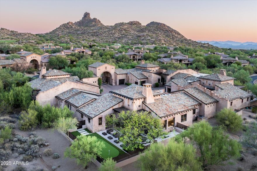 Step into timeless elegance with this beautifully designed home, where rustic charm meets modern comfort.
A striking stone entryway sets the tone, welcoming you into airy, light-filled spaces framed by expansive windows that capture serene desert views.
The open-concept living areas feature soaring ceilings, a sleek stone fireplace, and seamless flow between the great room, dining space, and chef's kitchen. The kitchen boasts custom wood cabinetry, a large center island with waterfall stone countertops, and top-tier appliances—perfect for both everyday living and entertaining.
Multiple seating areas offer comfort and style, from the cozy breakfast nook with its own fireplace to the inviting family room designed for gatherings. The primary suite is a private retreat with a spa-like bath, complete with dual vanities, a soaking tub, and a glass-enclosed shower.

Outside, thoughtfully designed landscaping complements the architecture, while outdoor living spaces invite relaxation and connection with nature.

This residence blends sophisticated finishes, warm textures, and architectural charactercreating a home that is as welcoming as it is impressive.

Experience desert living at its finest in this stunning blend of rustic charm and modern luxury.