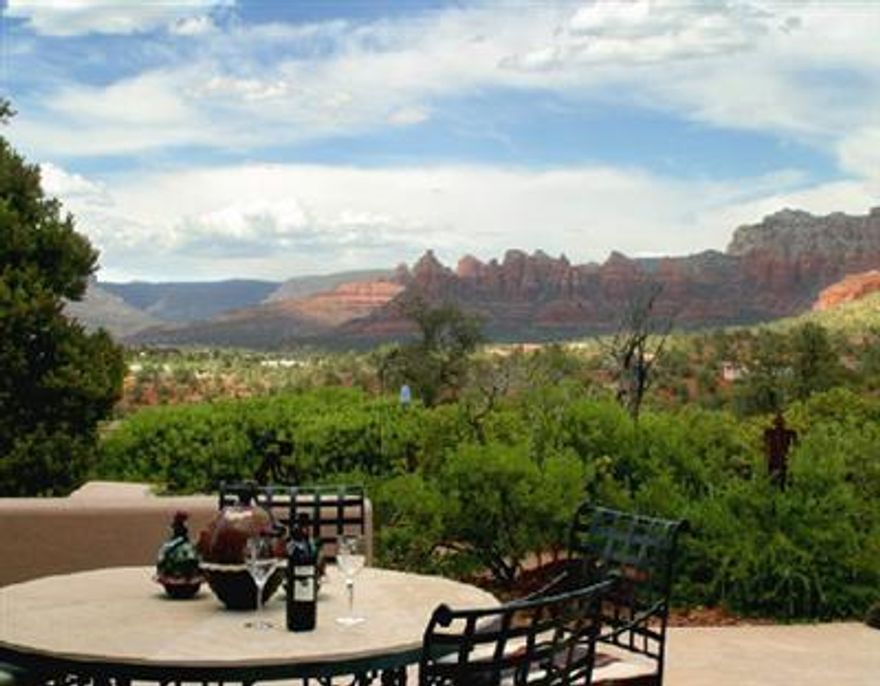 HILLTOP HACIENDA on 1.46 acres. Breathtaking mountaintop panorama commands center stage. Approximately 8900 sqft with luscious master suite, gourmet kitchen, large entertaining area, studio with bath and media room plus separate guest wing with two bedrooms, two baths and family area. Grand scale architecture impeccably detailed to emulate an authentic adobe featuring natural flagstone floors and rustic wood accents. Community pool and tennis. All furnishings, fine art, available separately. Sensational!