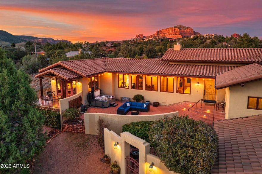 Stunning 4.14-acre estate in the Village of Oak Creek. This unique property is a very private oasis or an equestrian haven. The dramatic attention to every detail of this gorgeous custom home - Southwest Hacienda style, built with modern mountain architecture design, featuring exquisite high vaulted tongue/groove knotty pine ceilings, wide hallways, oversized interior solid wood doors with floor to ceiling windows giving natural light throughout. The oversized glass double doors opening out to decks and patios allows incredible viewing of the unobstructed views of the forest land, red rocks, mesas, and mountains. The living space is on a single level with an exterior concrete walkway which easily accommodates assisted walking needs. Flooring is octagonal shaped Saltillo tile with matching accent tiles placed throughout the home, carpeted bedrooms. The large primary suite has it's own private patio, with beautiful mesa/forest views to sip your sunset refreshments from. Also features a walk-in closet with light tube, spacious bath with separate glass enclosed shower, oversized tub, and separate commode room, black out Hunter Douglas blinds, and its own separate HVAC system. The ample sized guest bedroom has its own private full bath, blackout blinds, and beautiful red rock views. The large well designed gourmet kitchen with island, beautiful Cherrywood cabinets granite countertops two sinks with individual disposals, breakfast bar, GE stainless Profile/Monogram propane cooking appliances, Bosch dishwasher, and beverage refrigerator is perfect for large gathering/entertaining and easy accommodations multiple cooks. The large pantry, office space, and laundry room adjacent to kitchen, keeps the traffic pattern to a minimum. A separate 597 sq. ft. casita has a large bedroom, full bath, large living room, spacious kitchenette, and its own HVAC system. The goal was a high end design to show like a dream so when guests arrive, they will be eager to stay here in their own private getaway. An oversized two car garage has built-in floor to ceiling storage cabinets with access to store more under the home in a fully cemented storage area suitable for wine and seasonal storage. Only two owners of this estate, and meticulous to detail and upkeep make this highly valued. If you're looking for a home that is an easy to maintain yet entertaining oasis both inside and out, a minute to town, close to award winning golf courses, walking distance to hiking trails, dark sky ordinance allowing for beautiful year round star gazing, nature setting with trees and foliage, this extremely well groomed/cared for property is truly for you! Come see this unique and special property- STUNNING !
