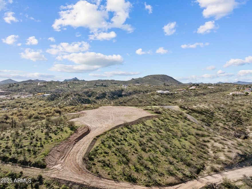 This 2+ acre parcel comes ready for the lifestyle a lot of people talk about but never quite pull off. Cleared building site, shared well, open usable land, and views that remind you why people keep moving out this direction in the first place.
Located near Simpson Ranch, it's well-positioned for horse and rodeo living, whether your days involve hauling, training, riding, or just owning an unreasonable amount of equipment with wheels.
Mountain views in front, city lights behind, and enough open space to make life feel a little less crowded and a lot more Arizona.