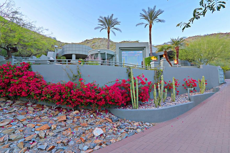 Nestled against the mountain preserve, this premium hillside home embodies Tatum Canyon luxury living!  Walls of glass and expansive wraparound patios combine with a perfect elevation to showcase the panoramic views of Camelback and surrounding mountains.  Situated up a privately-gated drive boasting six en-suite bedrooms and seven baths, its features include a sleek kitchen, office, theater, wine room, fitness center with a spa bath, resort-style pool and multiple outdoor entertainment areas.  For privacy reasons, photos are limited.  Additional photos available by request.