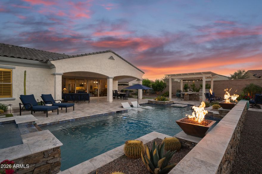 Single story pool home with a golf course lot on the 11th hole of the Victory course with panoramic views of the white tank mountains on an oversized lot in the active adult community, Victory. The moment you open the front door you are welcomed by a 19 foot slider opened to a backyard oasis with heated pool, spa, fire features, fire pit, outdoor BBQ & bocce ball court. Custom white shaker kitchen with large island, stainless steel appliances & walk in pantry.  Wood beams cover the ceiling of the kitchen & living room area.  Master bedroom overlooks golf course with mountain views Master bath with dual vanity sinks, walk in shower, custom shelving in master closet & access to the laundry. Home has an additional 2 bedrooms, bath plus office with doors. Community has golf, spa, gym & more