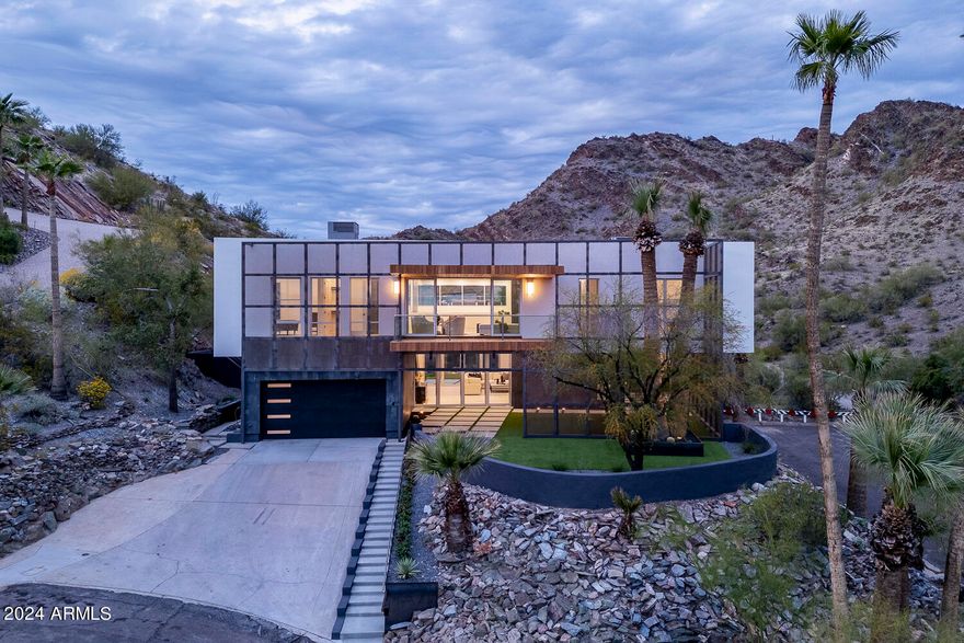 Biltmore Highlands, located on a hillside bordering the Phoenix Mountain Preserve Piestewa Peak. This residence combines nature's tranquility with urban convenience, offering breathtaking & unobstructed mountain, and city views! Minimalist-style kitchen with ample storage, and a complete butler pantry. The primary bedroom has a sizable walk-in closet w/built-ins and a lavish ensuite with dual sinks & soaking tub. The upstairs laundry room is complete with sink & cabinetry. Discover the entertainer's backyard, where an elevated negative edge pool awaits for refreshing swims, or chill and take in the mountain views. The rooftop party deck is an excellent spot to savor those amazing sunsets complete with an outdoor kitchen. You have a private gate to access the Phoenix Mountain Preserve! The scrim that covers the front and east side of the home creates a solar passage, increasing efficiency, privacy, and once it rust it will allow the home to blend with its desert surroundings. A huge covered patio in front of the home allows you to enjoy indoor-outdoor living when opening your matching 4-panel pocket doors and 8 pivot doors, doubling your space for entertaining. World-class hiking right out your back gate! Just Minutes from Old Town Scottsdale, Sky Harbor Airport, and downtown Phoenix. Located near the 51 freeway, without the noise, that gets you to the 10 or the 101 freeways in minutes.