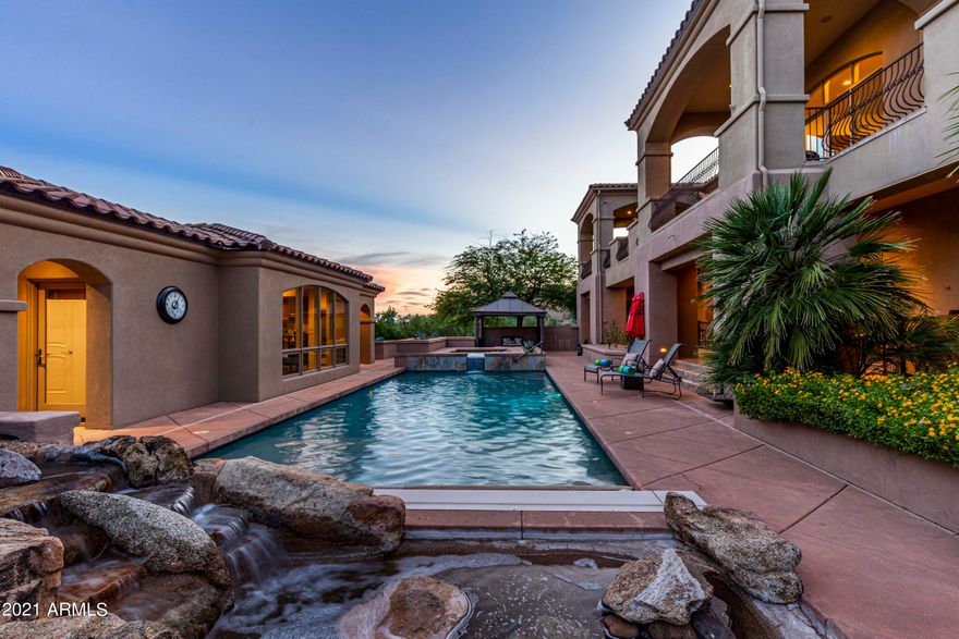 A magnificent estate built for comfortable living or lavish entertaining. Perched in the gated enclave of Eagle Mountain, this exceptional property boasts endless city light & mountain views.  For the car enthusiast this EIGHT car climate controlled garage is for you!  The home provides a total of 7523 square feet of which 575 square feet can be found in the private guest quarters complete with kitchenette and full bath.   In addition to the executive style office and powder room, the owner's suite stands alone. The breathtaking views will draw you to the private balcony which provides access to the backyard. The spa like bathroom will compel rejuvenation with the oversized steam shower, jetted tub, split dual vanities,  gorgeous stone throughout, and massive closet. Just off the formal dining and living rooms which have exceptional views, you will find the eat-in kitchen which is a culinary delight with an oversize wood paneled fridge, stainless steel double wall ovens, incredible woodwork, a Thermador gas cook-top with griddle and gorgeous granite.   A massive pantry is the icing on the cake as you will find plenty of room to store kitchen appliances as well as food!  You will also find a large laundry room with all the bells and whistles making doing laundry fun again.  Venture back to formal living and dining room, which are also surrounded by more views! These two formal spaces share a full size wet bar and a stand alone dual gas fireplace adding the ambiance you are looking for when entertaining or just sharing family time.  Take note of the Brazilian Tiger wood flooring as you take a stroll down one of the two staircases or the elevator and find yourself on the lower level complete with three en-suite bedrooms, a second quiet study area with built in cabinetry, and a media room that is better than being at the movies! There is even a small kitchenette and room for the popcorn machine.  The backyard is a true oasis with covered patios spanning both levels, a lap pool with motorized cover, spillover spa, a serene rock waterfall, a Pergola for additional outdoor dining, and the perfect amount of grass.  From the lower outdoor patio, you will also find direct access to the fitness room that rivals any gym!   Wind up to the expansive upper balcony and take in those views! You will have plenty of room for outdoor dining or chaise lounges to enjoy a good book and soak in those mountain views. It is on this level you will find an outdoor BBQ, and built in fireplace perfect for roasting marshmallows on those cool winter nights.  Access to the garage can also be found here.    This mammoth 8 car garage is perfect for all the toys and holds a second laundry facility.   HVAC units, pool pumps, water heater, and water filtration system have all been replaced in the last 3 years!  This is truly a one of a kind Fountain Hills Estates that will be well received by all.  Come see for yourself.