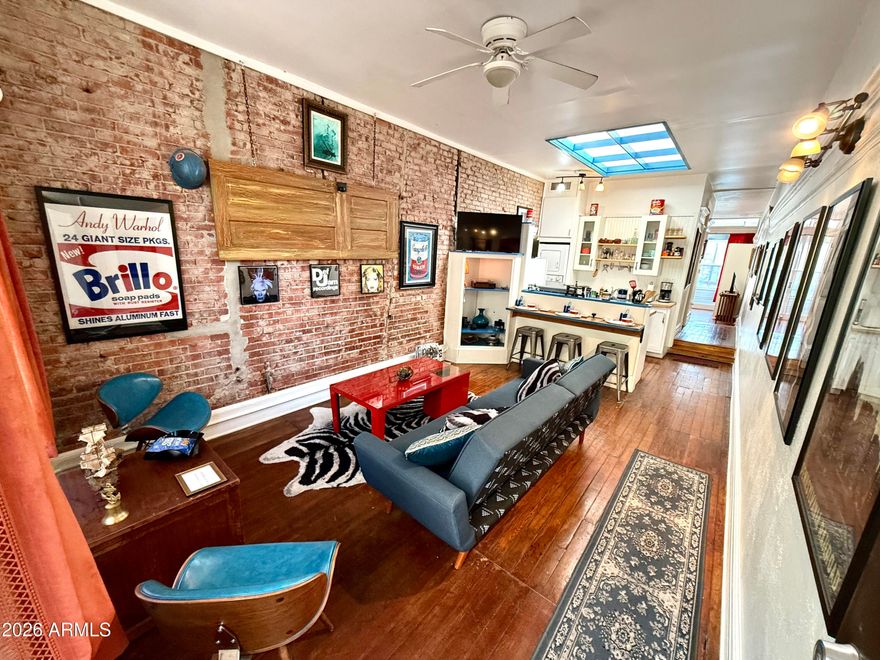 Upstairs is a beautifully appointed 809 sq ft 1-bedroom loft apartment with hip New York vibes, featuring original wood floors, exposed brick, & soaring ceilings & skylights. The views are unmatched. This gorgeous loft is a favorite on Airbnb, capitalizing on Bisbee's growing tourism market. 
At street level, is a restaurant space with seating room for 28+, complete with a commercial kitchen. An added bonus to this space is the huge storage cellar with time worn wooden timber stairs - wine cellar anyone? Keep 14 Main as it is or transform it with your imagination! HVAC on all levels for comfort. With its proximity to Main St's attractions & the town's reputation as a top travel destination (named one of Travel Lemming's 50 Best Places to Travel in 2024), Live, Work & Play all in one place This is an income producing property!  Street level commercial space has been leased to Skyhaven Wines.