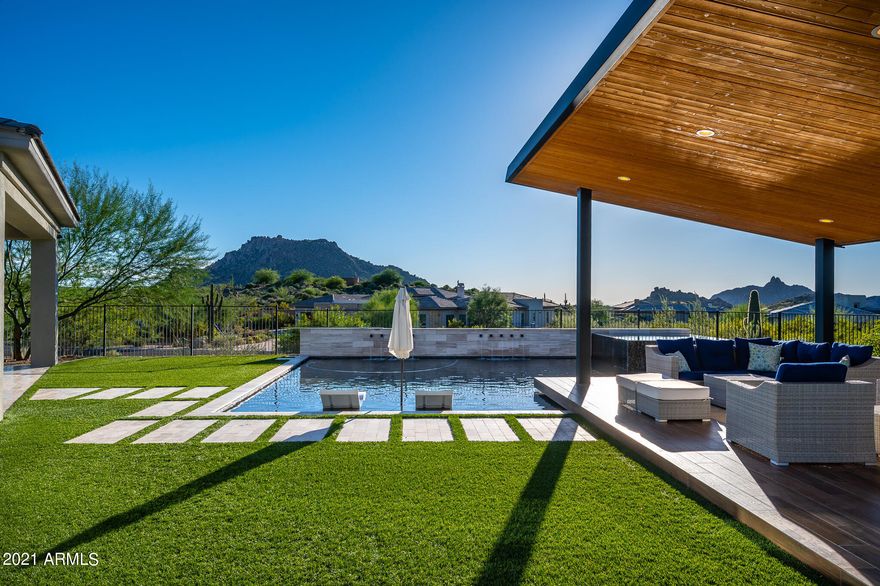 An exclusive find behind the notable gates of Talon Ranch, this picturesque residence exudes a visually stimulating style and sophisticated upgrades. Featuring dramatic entryways, ultra private courtyard, wine room, and vibrant bar to host the ultimate gatherings. Mural walls and custom ceiling soffits add a touch of dimension, intrigue, and style. The kitchen overlooking the Sonoran Desert was designed with sleek cabinets, stone counters, and premier appliances. There are two en-suite bedrooms, bonus room, office, and a casita. The primary suite has two closets, patio with hot tub, and spa-like bathroom with soaking tub and dual entry shower. Outdoors you'll find an iconic ramada, BBQ, firepit, pool with baja shelf and spa, expansive covered patios, and a rare variety of mountain views.
