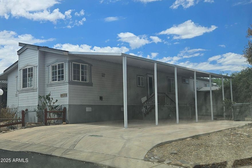 Fixer Upper but has a brand new roof and brand new carport. Large 1,674 square foot 2 bedroom, 2 bath with Den. Great room, formal dining room and breakfast nook, large primary bedroom with exterior door to covered patio.. Arizona Room enclosed at front of home offers additional square footage. Chain link fenced  yard. Two sheds. Property has beautiful large trees to include a Tombstone Rose Bush. Home does need work and being sold ''as is''. In a gated community.