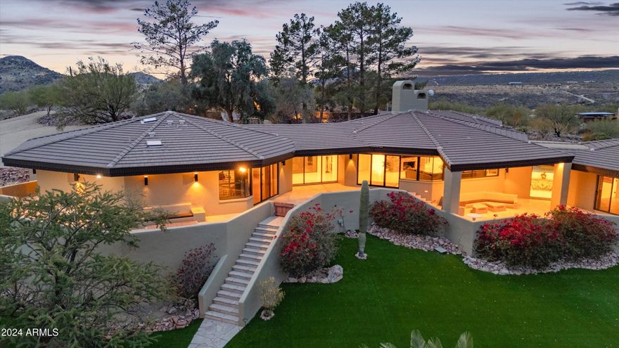 Perched atop 12½ acres, with breathtaking 360º views, this home showcases stunning vistas of Black Mountain, Tonto National Forest, and the  town of Cave Creek. The living room features a dramatic wall of windows framing the captivating scenery, a stone fireplace, and vaulted redwood ceilings. The split primary suite offers a private retreat with dual baths for ultimate convenience and comfort. Step outside to enjoy a new pool, a tennis court, and wrap-around patios. Horse enthusiasts will appreciate four stalls with auto waterers, 100x80 turnout and trail access. Whether you're enjoying the views from your wrap-around patio, watching  wildlife, or exploring nearby trails, this home is a true slice of paradise. MORNING STAR RD & 54th ST TO BE PAVED IN 2025.