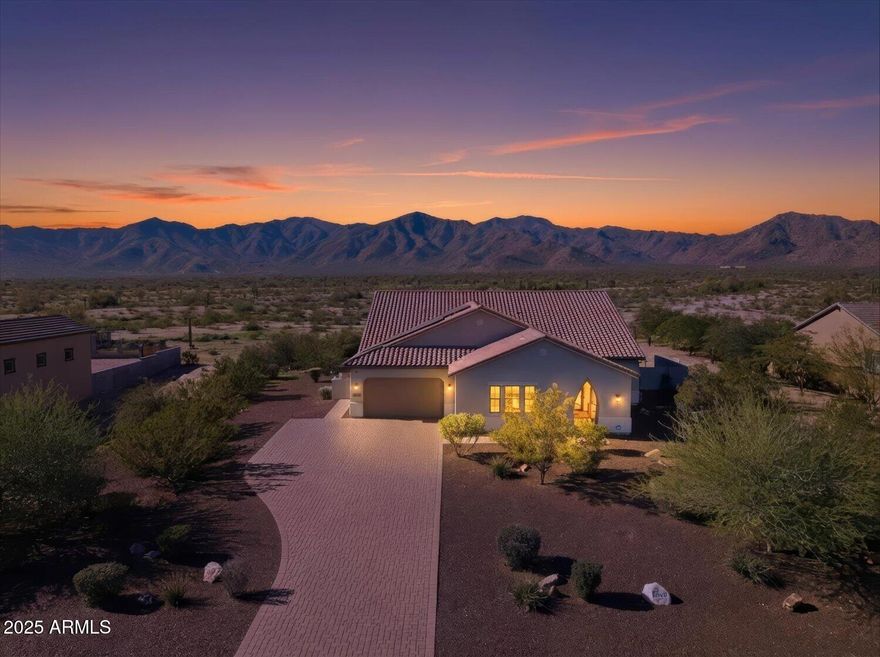 Nestled at the base of the stunning White Tank Mountains and bordering State Trust land, this beautifully designed 3-bed/3.5 bath home offers the perfect blend of space, style and Arizona outdoor living. The open-concept floor plan is filled with natural light, highlighted with expansive full patio doors. THE large backyard features a covered patio, grassy area and splash pad - perfect for entertaining and relaxing year round. A spacious 3-car garage provides ample storage, while OWNED SOLAR and EV charge adds energy efficiency and long-term savings. Enjoy mountain views, thoughtful design and a prime location that captures the best of desert living.