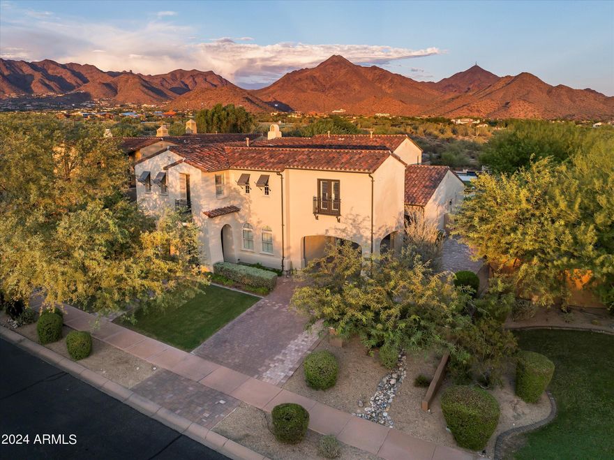 Highly sought after, gated DC Ranch Hacienda on one of a kind, oversized lot is tucked on an exterior cul de sac street with amazing curb appeal, faces open preserve and backs to natural area with picturesque McDowell mountains. Capture serene mountain and city light views from multiple areas of the home.  Desirable great room home plan features 5 bedrooms, 4 baths, downstairs office and plus an upstairs office/den with wine fridge bar, and an expansive flex bonus room upstairs, with charming interior courtyard for entertaining.  Enjoy seamless indoor/outdoor AZ living with a telescoping glass door from great room to picture perfect resort style backyard with scenic mountain backdrop, featuring oversized grassy area plus garden planters, outdoor covered ramada adjacent to generous heated pool and spa, and linear firepit, built-in BBQ with seating, covered patio, with ample hardscape space for seating/lounging. Stunning designer finishes including oak hardwood flooring throughout the home, light and bright oversized eat-in kitchen island, chic statement vent over gas range overlooking backyard, refined marble and tile selections throughout for a polished sophisticated appeal.   Breathtaking views from second level primary suite with sitting area overlooking majestic McDowell Mountains, enjoy generous wardrobe, and spa like bath with freestanding bubble soaker tub. Convenient utility room with hall tree, three car tandem garage with cooling unit, plus spacious additional paved parking for four more cars.  Quaint neighborhood park nearby. This showstopper is a unique opportunity in the coveted DC Ranch Haciendas.
