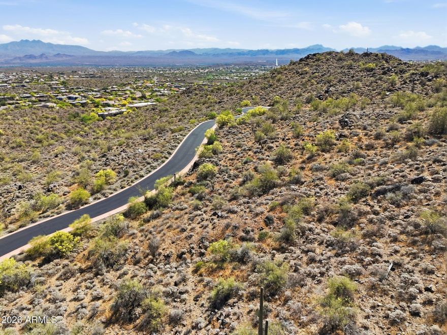 A phenomenal opportunity to create a truly bespoke hillside desert retreat within the prestigious, guard-gated Eagles Nest community. This expansive homesite captures breathtaking panoramic views of the surrounding Sonoran Desert, the iconic Four Peaks, and the renowned Fountain Hills Fountain. Set within this exclusive enclave of custom estates, Eagles Nest offers a rare blend of serenity and refinement, yet just minutes from world-class golf, scenic hiking trails, upscale shopping and dining, and the vibrant art and cultural experiences that define Fountain Hills living.
Included with the property are plans for a striking contemporary residence designed by the acclaimed PHX Architecture. Thoughtfully conceived to complement the natural landscape, the design features open-concept living dramatic floor-to-ceiling glass, and a seamless indoor-outdoor flow. Bring this vision to life with Weber Construction, renowned for their outstanding craftsmanship and meticulous attention to detail, or select your own builder to create a home that reflects your personal style and vision.
This is an invitation to build something truly opulent, intentional, and uniquely yours