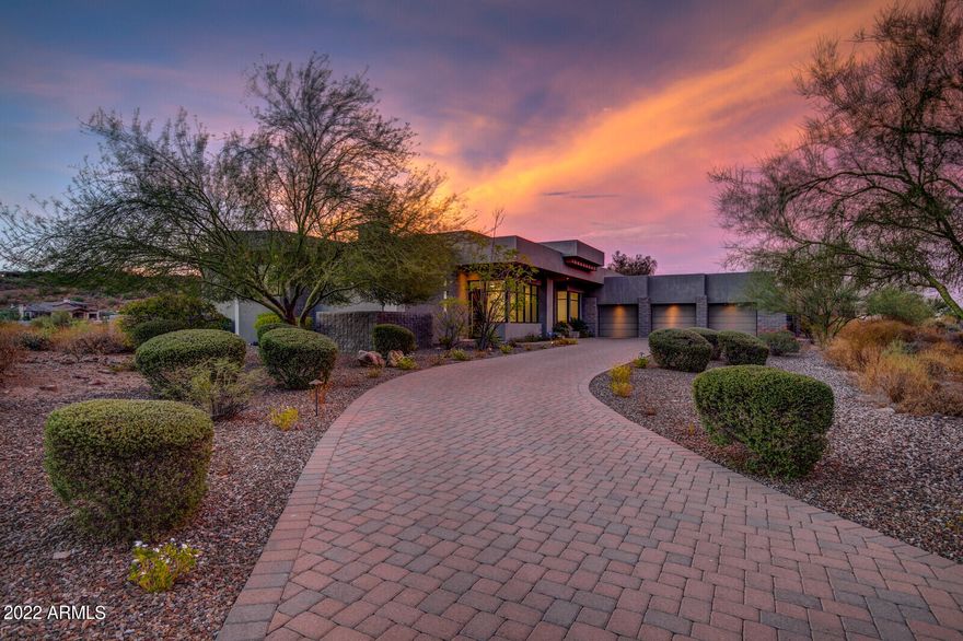 Entertain effortlessly. Live Lavishly. A premier piece of architectural artistry within FireRock Country Club with emerald views of the 14th hole. This zero grade home features an unmatched entirely flat lot from the driveway to the pool and is being sold turn-key. Enjoy a truly unheard of smart home with no steps throughout along with an incredible 8 car air conditioned fully insulated garage. Step inside and instantly notice a 21st century design with clean lines, elegant marble flooring, soaring ceilings, and a window-lined open concept. Designed as a focal point, the living room inspires both drama and tranquility with 24' pocketing walls of glass, stunning fireplace, and surrounding sightlines that encompass mountain, fairway, and natural desert landscaping. The chef's kitchen is appointed with two islands, dual sinks, double wall oven, gas cooktop, stone countertops, breakfast bar, walk-in pantry, and breakfast nook. Compelling rejuvenation, the master retreat is split from the rest and is complete with its own fireplace, private pool access, sitting area, custom dual vanity, regal soaking tub, separate glass shower, and a massive custom walk-in closet. All with their own outdoor entrances, two additional junior suites and a full office (or 4th bedroom) with its own full bathroom are sure to please. Embrace any Sonoran Season with the low maintenance backyard featuring BBQ grotto, mister system, glass fire-pit, synthetic grass, and a triple tiered aquatic masterpiece with spillover spa, negative edge lap pool, and a second pool below. Step to the incredible garage, with its own bar with sink, full insulation,  HVAC system, built-in compressed air with nozzles throughout the garage, and two lifts included with sale making this an 8 car garage! Notable details of this home include an ADT home security security system with remote functionality and a Control4 home AV system that provides Audio video surveillance both inside and out, AC control, and remote garage open/close control. This home is being sold mostly furnished.