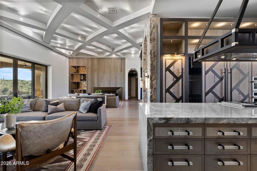 An architectural achievement reimagined by Jaque Bethke on an elevated 1+ acre lot in FireRock Country Club. This 6,007 SF, 5 Bed, 4.5 Ba, museum-quality residence blends raw elemental beauty with world-class technology. Anchored by three 3,000lb motorized amethyst/pink geodes, the home offers seamless single-level living via private elevator. Chef's kitchen features a 12' waterfall island & AI-powered hood. Wellness primary suite boasts Red Mountain views, 4-zone heated floors & steam closet. Fully automated via Josh AI, Control4 & Lutron. The ''Collector's Dream'' garage features 4 over-height, extended-length bays prepped for lifts to accommodate up to 8 cars. Entertainer's backyard with negative-edge pool & spa overlooking Four Peaks & city lights. This is a curated journey in the Sonoran Desert, designed for effortless living and sophisticated entertaining.  The entire living experience is contained on a single main level. The culinary hub is a masterpiece of form and function, a 48" gas range, custom steel and light AI powered hood, and a high-utility butler's pantry. Adjacent to the casual living areas, the home offers a state-of-the-art home theater with a 10-foot screen, an executive home office, and guest suites featuring private balconies. Residents can enjoy the warmth of a sleek fireplace while taking in unobstructed, sweeping views of Red Mountain, creating a resort-level atmosphere within the home. With Smart Home technology, every element of the home's environment, from lighting and climate to security and media, is integrated for intuitive use.  The "Entertainer's Dream" backyard is designed to showcase Arizona's natural beauty. Expansive travertine patios offer a front-row seat to spectacular sunsets, shimmering city lights, and iconic views of Four Peaks and Red Mountain. With a built-in BBQ and multiple lounging zones, the outdoor space is an extension of the home's elemental luxury, completing this architectural masterpiece.