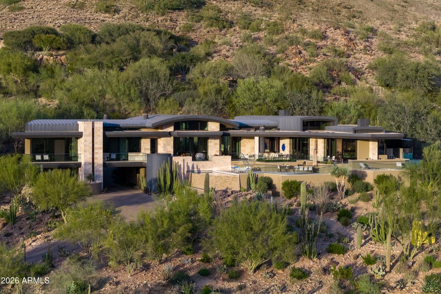 World famous Architect, Bing Hu, and world class Builder, Kitchell; created this commercial grade, modern art view estate, on arguably the best lot in Paradise Valley, Arizona.  With a gentle sloping grade and walkable neighborhood, the scenic gardens greet guests to the gated mountain home.  Carved into Mummy Mountain where privacy intersects expansive, unobstructed views of Camelback Mountain, downtown City Lights, Phoenix Mountain Preserve and Mummy Mountain.  The home was designed with intention & quality focused on views, livability, and the home's integration of nature as a work of art itself.  Every view, every line, every material, every structural component reflects enduring quality and precision engineering to last generations.  Homes of this caliber rarely become available.
