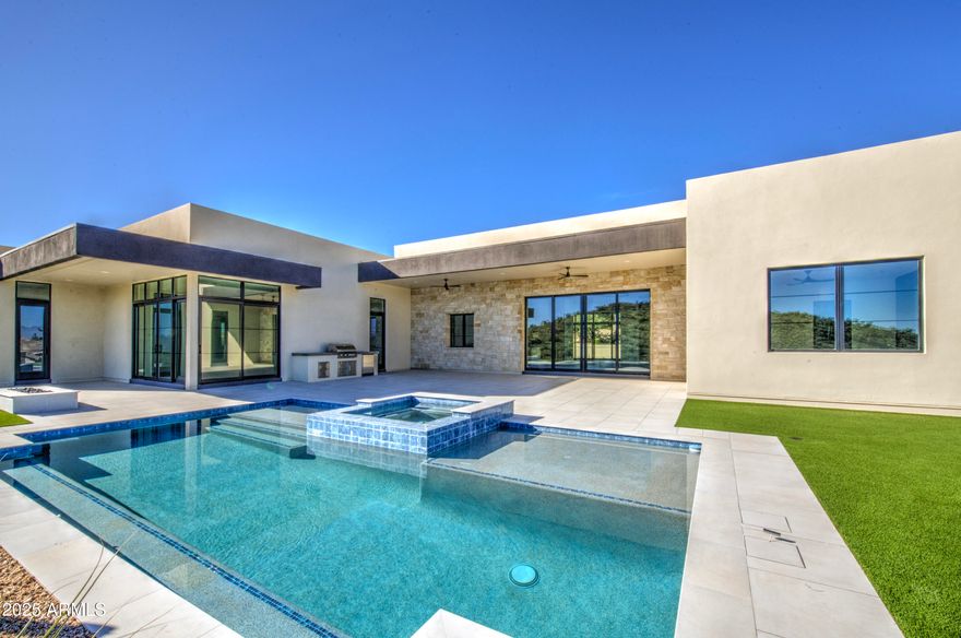 You are about to fall in love with this stunning custom property located in the amazing gated subdivision of Palatial Estates in Fountain Hills.  Located on a hill with beautiful views the home has contemporary touches everywhere you look. Step inside to an elegant entryway. There is wall to wall wood flooring and Cathedral-like high ceilings in the great room area.  Enormous kitchen and a kitchen that has it all including butler's pantry, wall ovens, contemporary light fixtures, granite countertops, and beautiful upgraded cabinetry with all the storage space you could dream of. Split floor plan with the primary bed on one side of the home and 3 large secondary bedrooms on the other. Formal dining room with  wine closet. Separate living & family rooms. You'll spend a lot of time entertaining and relaxing in the backyard that has covered patio, sparkling swimming pool, in-ground spa, built in BBQ, no-maintenance landscaping, and views to take your breath away.  Come see this beauty for yourself. You won't be disappointed.