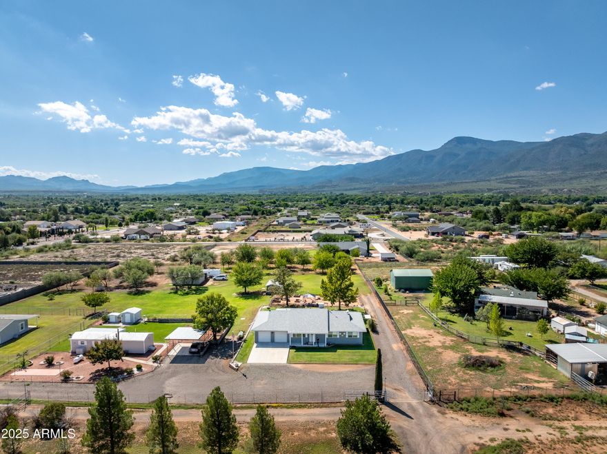 Lovely, well-maintained home on a lush, green acre+ with mountain views in Camp Verde.  There is a large garden plot with a green house.  Out buildings include a gazebo, gardening shed, and chicken house.  There is an orchard with eight, mature fruit trees.  The well is in a covered shed, and provides the water for the landscaping .  The home has three bedrooms with 2 full baths.  There is a large room off the kitchen that could serve as an additional bedroom with a 1/2 bath, or a family room.  The great room opens into the kitchen/dining area with an electric fireplace.  The kitchen has a large island with butcher block counters and white cabinets.  There is ample storage throughout the home with a large food pantry and linen closet.  The large laundry room includes a utility sink. The color palate is neutral and pastel.  Lots of large windows create a light, interior environment.  You will want see this "oasis" in the desert. Sellers are MOVIVATED