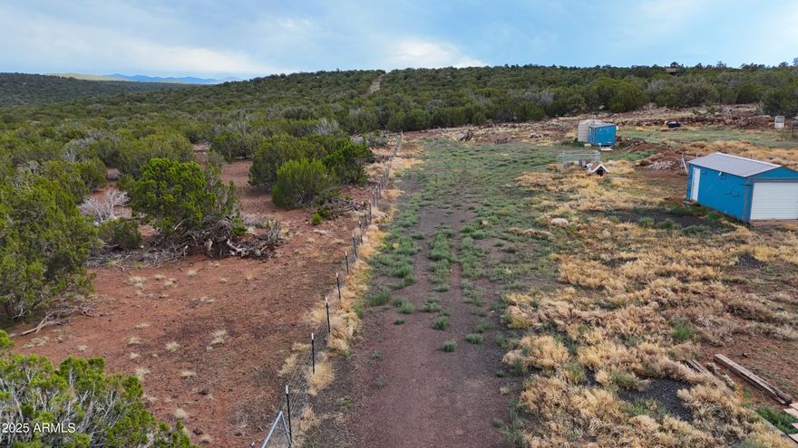Discover the perfect blend of off-grid functionality and scenic tranquility on this level 2.4-acre parcel — ready for your designing. It includes a 12' x 24' Graceland building, ideal as a cabin, workshop, or storage. A separate insulated 8' x 12' structure—perfect for a utility room, office, or extra storage. Water & Power Ready with a Massive 5,000-gallon water storage tank for hauled-delivered water. Also included a Solar rack with 9 panels as well as a 500-gallon propane tank, offering energy independence. The entire property is fully fenced—great for privacy, pets, or livestock. Easy access and flat terrain—ideal for building, gardening, or recreational use with Stunning Views of the surrounding landscape - sunrises, sunsets, and stargazing await. Whether you're looking for a homest The entire property is fully fencedgreat for privacy, pets, or livestock. Easy access and flat terrainideal for building, gardening, or recreational use with Stunning Views of the surrounding landscape - sunrises, sunsets, and stargazing await. Whether you're looking for a homestead, weekend retreat, or an investment in your off-grid future, this property checks all the boxes. Septic in place, land prepped, and freedom to create your dream.