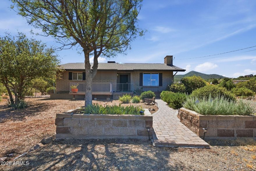 Set in a picturesque setting in Dewey-Humboldt, this brick ranch on over 2 fully fenced ac captures sweeping mtn, valley, & city-light views. This property features horse privileges, spacious living areas, a wood-burning fireplace, walk-in closets, oversized garage, dual gated entry, & multiple storage bldgs. Including 30 x 60 RV shop & an oversized 2-car garage up to a 10 car storage. Improvements include a new septic system with an 80' leach field installation, upgraded RV electrical hookup, gutters, thermostat, pump house addition, utility room updates, landscaping enhancements, driveway improvements, & outdoor lighting. The long views enhance the enjoyment of privacy, paved access, nearby trail riding, & the peaceful beauty of living just minutes from town conveniences.
