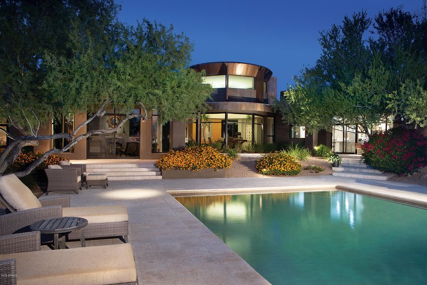 This sensational contemporary home rests on Desert Highlands only 5.16 acre home site abounding with Pinnacle Peak, McDowell Mountain and city light views. Designed by renowned architect Barry Berkus. the home's 6,726/sf living area plus a 517/sf guest house is all on one level (SEE FLOOR PLANS IN DOCUMENT FOLDER). It includes a marvelous kitchen with high end stainless appliances, an adjoining family room and kitchen office, a Great room, formal dining room, a swank office with adjoining circular library, wet bar, 3 bedrooms and 5 baths. The posh master suite overlooks Pinnacle Peak and sunset views and sports his and her separate baths and closets. The open staircase to 2,103/sf basement level is alongside a full glass wall view of the outdoor water feature opening to a rec/media room... fitness room and an art studio..that could be converted to another bedroom as it has an adjoining full bath. The two room guest house includes a kitchenette. Car lovers will love the 6+ car garage. Outdoors is exquisitely landscaped with spectacular pool with water feature and multiple fountains. A great place to relax and enjoy the views. Desert Highlands amenities include Jack Nicklaus Signature Golf Course (HOA fees included golf tee fees for all immediate family members including children under 25), driving range, 18 hole putting course (nearly 400 yds), Racquet club and 13 tennis courts (4 grass), award winning clubhouse with fine and casual dining, 10,000/sf fitness center, garden amenity, walking paths, guard gated and security patrolled.