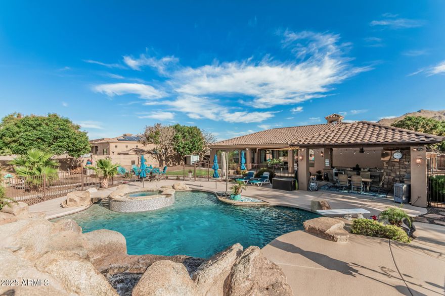 RESORT-STYLE LIVING AT ITS FINEST! Enjoy the best of both worlds with a coveted Queen Creek address, Gilbert utilities, and no HOA. This exceptional property offers your own private oasis, seamlessly blending luxurious indoor comfort with breathtaking outdoor living. Step outside to an expansive entertainer's patio, complete with a built-in outdoor kitchen and generous dining space--perfect for unforgettable evenings under the stars. The heated pool and spa are truly showstopping, featuring a grotto, tube slide, and diving board for the ultimate resort experience right at home. Inside, the home impresses with a grand living area, soaring ceilings, elegant finishes, and effortless access to the backyard. Continued... With 5 spacious bedrooms and 3.5 bathrooms, plus an additional poolside half bath, there's room for everyone to relax and unwind. The chef's kitchen is fully upgraded with brand-new KitchenAid appliances, an induction cooktop, granite countertops, a large walk-in pantry, and abundant storage--perfect for both everyday living and entertaining. Set on nearly an acre, the property includes irrigation and mature citrus trees--five navel orange, one Meyer lemon, and one lime tree--adding charm and the perfect touch for fresh, poolside cocktails. This rare, turnkey property delivers a true paradise inside and out. Opportunities like this don't come often--make it yours today!